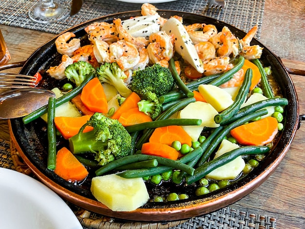 Camarones a la plancha en mantequilla de finas hierbas, con verduras salteadas.