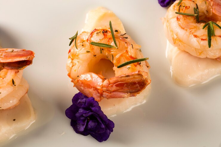 Camarones a la plancha con pescado crudo de uñas en un plato blanco en la mesa
