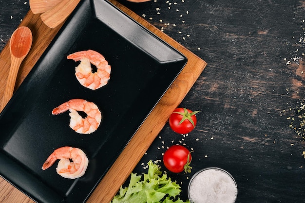 Camarones y platos grandes Sobre un fondo de madera Vista superior Copiar espacio para el texto