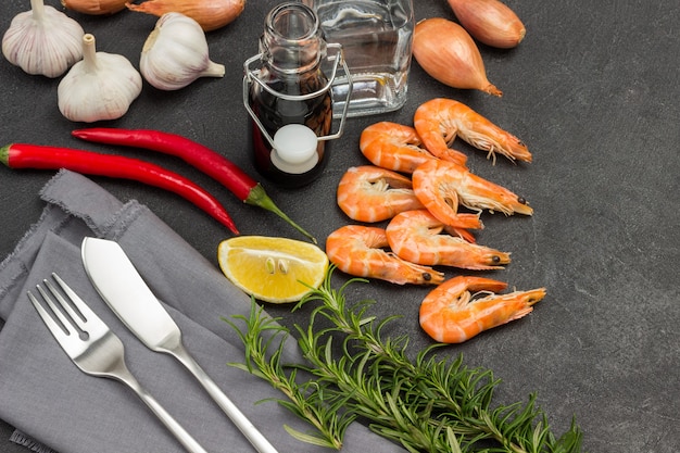 Camarones, Romero, Chile, Pimienta De Jamaica, Limón En La Mesa. Tenedor y cuchillo en servilleta gris