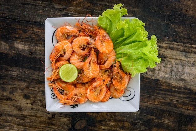 Camarones salteados con ajo y aceite en manjar blanco sobre mesa de madera Comida brasileña.