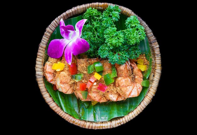 Camarones salteados con salsa y verduras aisladas en el fondo negro