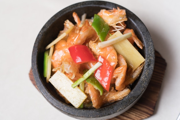 Camarones salteados en un wok con platos en el plato.