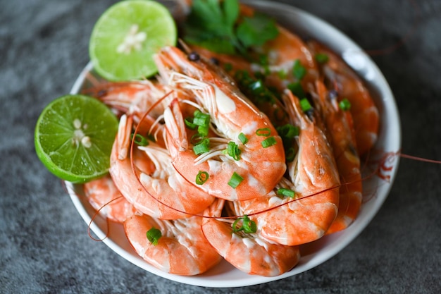 Camarones sobre bolw blanco y fondo de madera mesa de comedor comida Camarones frescos langostinos mariscos lima limón con hierbas y especias