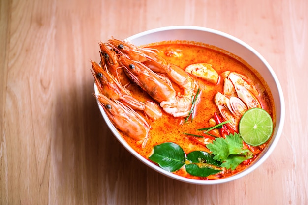 Camarones de sopa picante tailandesa en leche de coco o Tom Yum Goong en mesa de madera