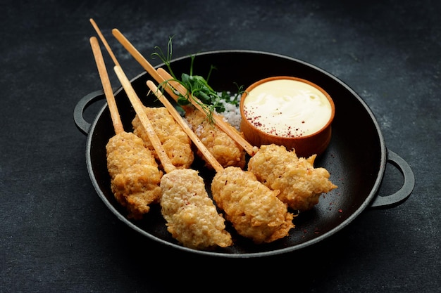 Camarones tempura en un palo de madera en una sartén