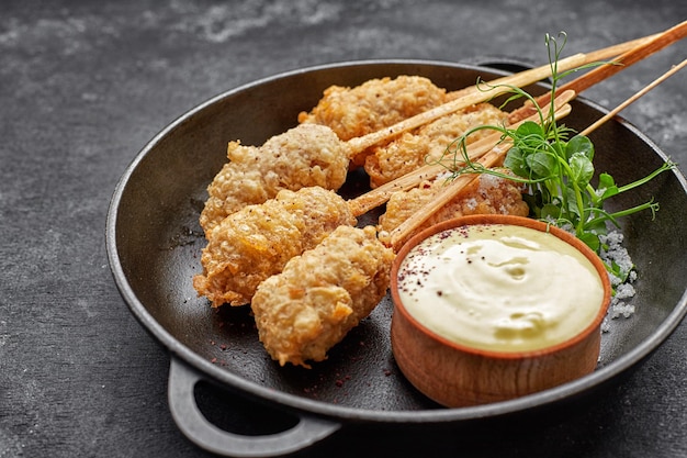 Camarones tempura en un palo de madera en una sartén