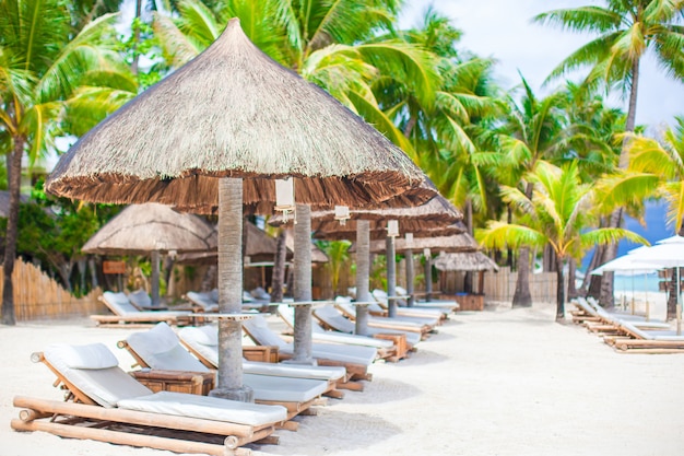 Camas de praia em resort de luxo na exótica praia de areia branca tropical