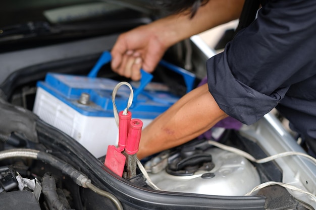 cambiar el mecánico de la batería del coche está comprobando el motor