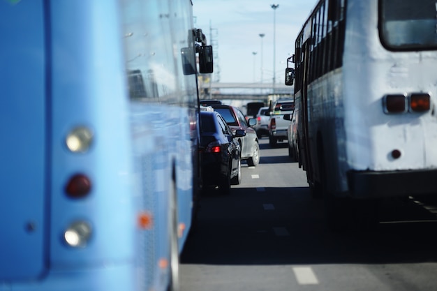 Foto cambio de carril de minitruck en carretera de tráfico lleno de gente en la hora pico vista entre autobuses