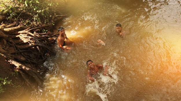 Camboja battambang crianças nadam e se divertem em um rio rural