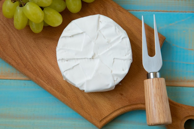 Foto camembert com garfo para queijo e uva vista superior