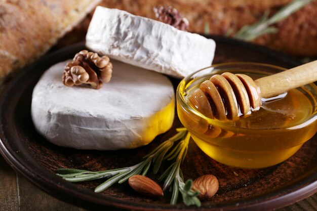 Camembert-Käse auf Platte Honig Nüsse und Brot Nahaufnahme