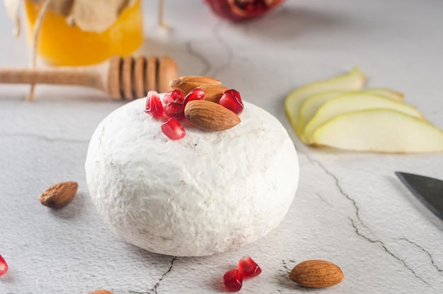 Camembert-Käse mit weißem Schimmel, Walnüssen, Honig und getrockneten Früchten Abendessen oder Aperitif-Konzept