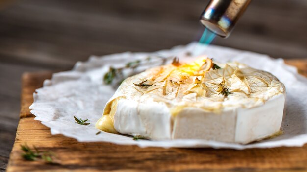 Foto camembert ou queijo brie grelhado no forno quente ou frito com molho de frutas vermelhas ou geléia.