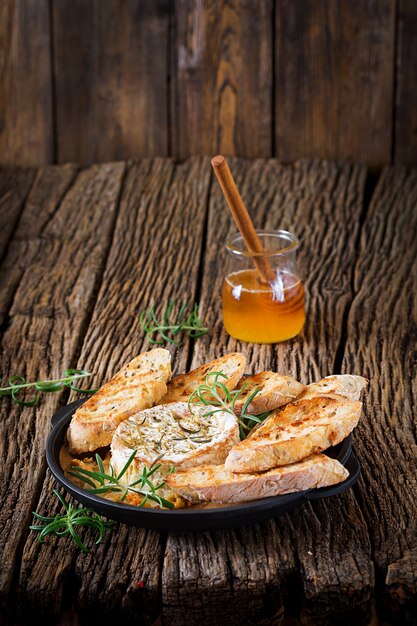 Camembert de queso al horno con romero y miel. Comida sabrosa.