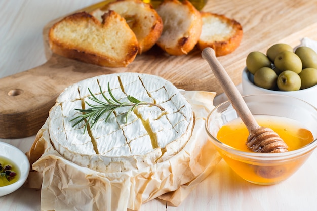 Camembertkäse mit Toastbrot auf hölzernem Hintergrund.