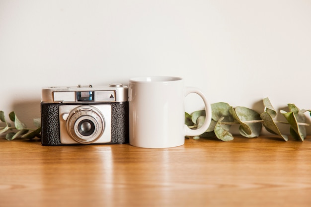 Foto câmera ao lado da caneca