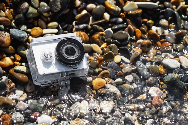 Câmera de ação branca com caixa subaquática na praia de calhau