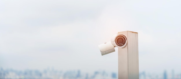 Câmera de CCTV moderna contra registro de vídeo de vigilância de fundo de cidade e céu e conceito de monitoramento