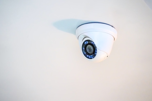 Câmera de CFTV branca pendurada no teto.