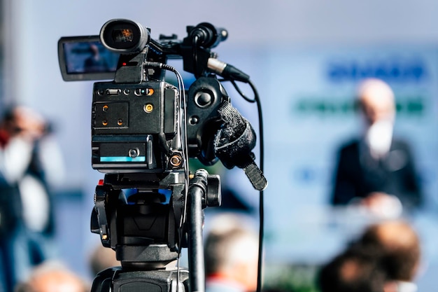 Câmera de evento de mídia gravando palestrante masculino no palco