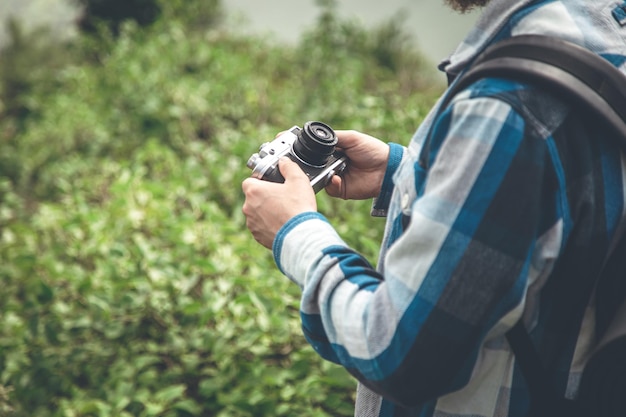 Câmera de filme vintage em mãos masculinas em uma caminhada na natureza