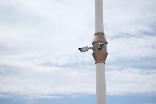 Câmera de segurança CCTV operando contra o céu azul com espaço de cópia