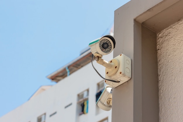 Foto câmera de segurança cctv ou sistema de vigilância em edifício de escritórios no fundo do céu azul