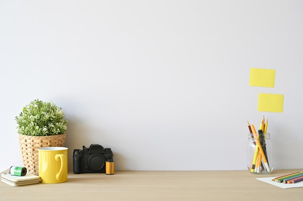 Câmera e materiais de escritório criativos do espaço de trabalho na mesa de madeira com espaço da cópia.