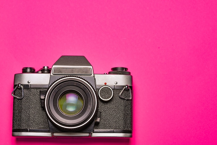 Foto câmera em um espaço rosa. conceito de viagem e fotógrafo