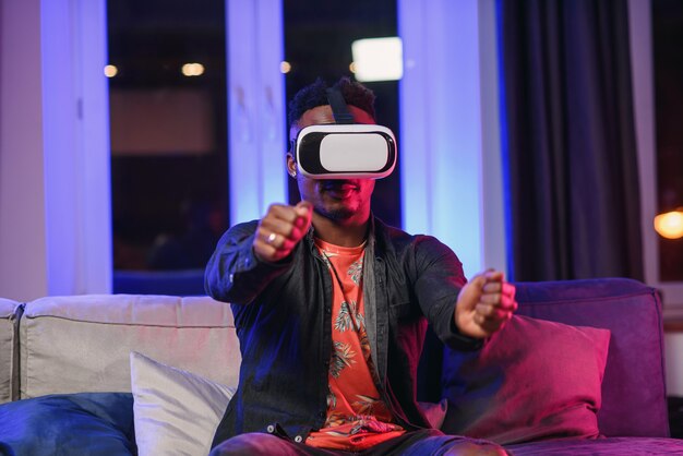 Câmera lenta de positivo alegre alegre afro-americana de 30 anos que usando óculos de realidade aumentada, movendo as mãos no ar como na tela virtual