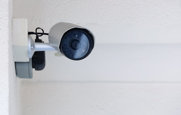 Câmera pública CCTV moderna em parede de cimento dentro do prédio com espaço para cópia