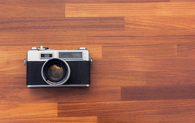 Câmera retro colocada em um piso de madeira escura