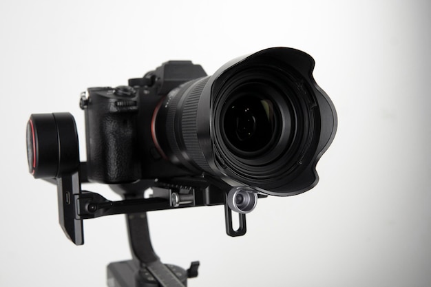 câmera sem espelho DSLR montada em um estabilizador eletrônico em um fundo branco