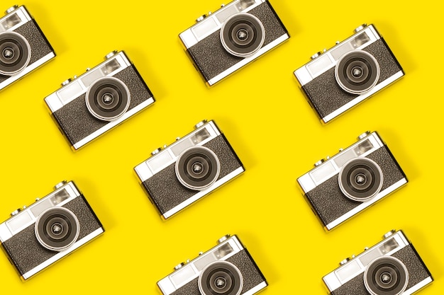 Câmeras fotográficas vintage em um fundo amarelo com espaço de cópia