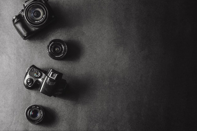 Foto câmeras profissionais com lentes diferentes em um fundo preto.