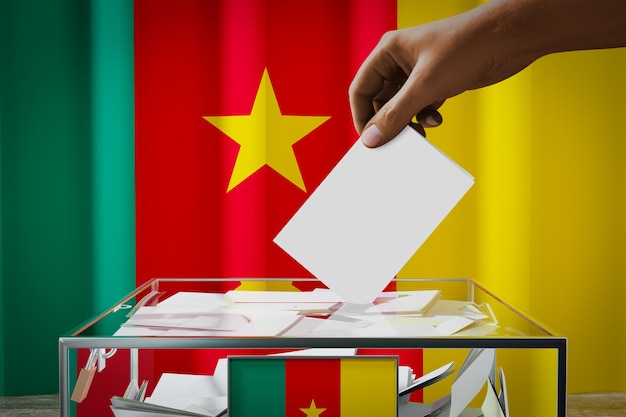 Camerún bandera mano dejando caer la tarjeta de votación en un concepto de elección de votación de caja