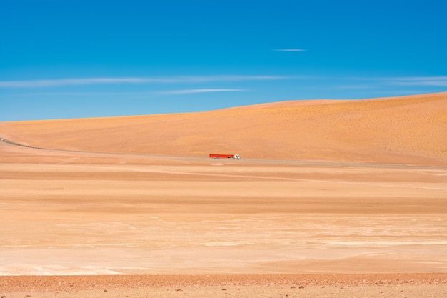 Camião a passar pelo deserto contra o céu