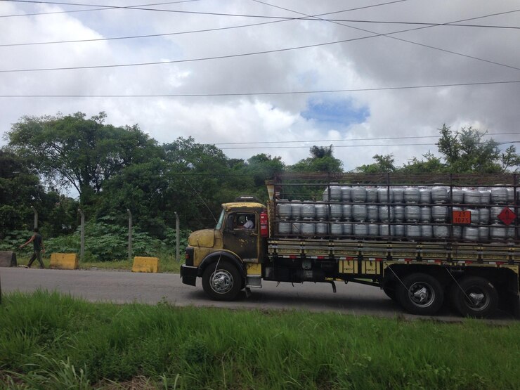 Foto camião de carga a mover-se na estrada contra o céu nublado