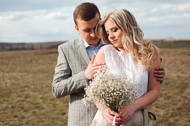 Camina la hermosa pareja de novios en primavera