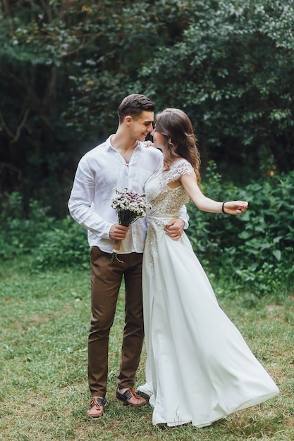 Camina los recién casados. La novia y el novio en la naturaleza. Día de la boda. El mejor dia de una pareja joven