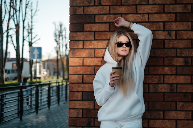 Caminando por la calle de la ciudad con una sudadera blanca