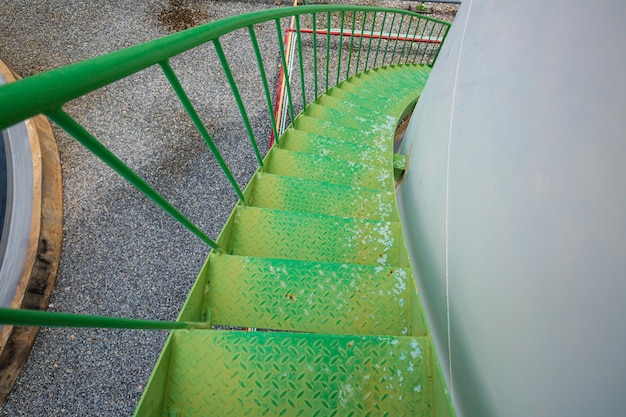 Caminando por la escalera tanque de almacenamiento verde químico