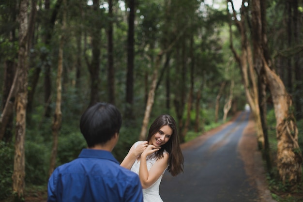 Caminando a la joven novia y el novio en el bosque