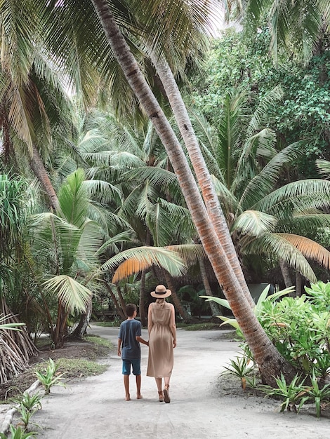 Foto caminando bajo las palmeras en las maldivas