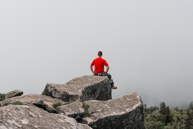 El caminante en la cima de la montaña disfruta de la vista aérea levantando las manos por encima de las nubes Monte Pidan