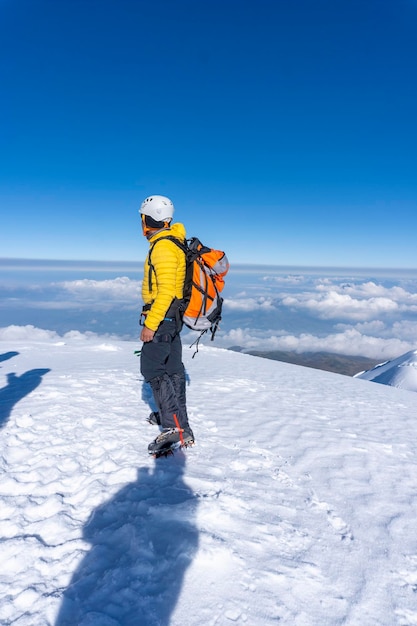 Caminante en la cima de una roca con las manos levantadas disfruta de un día soleado