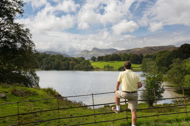 Caminante domina Loughrigg Tarn en Lake District