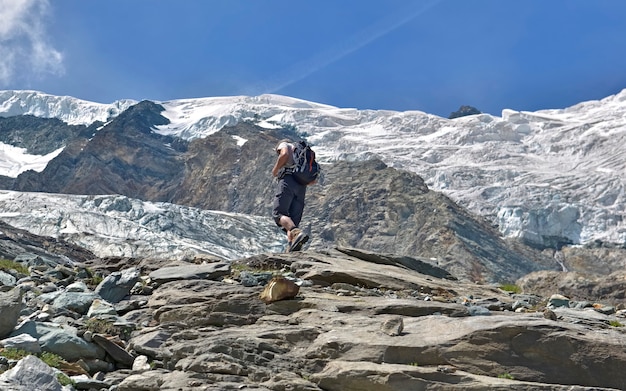 Caminante escalando un glaciar alpino en verano